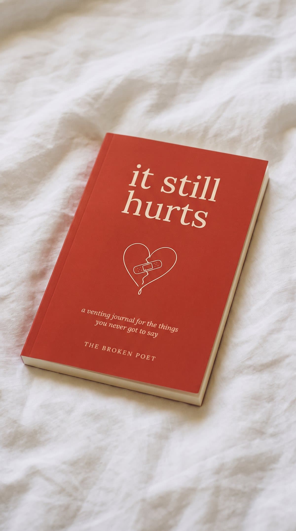 it still hurts on a rumpled white bed in morning light